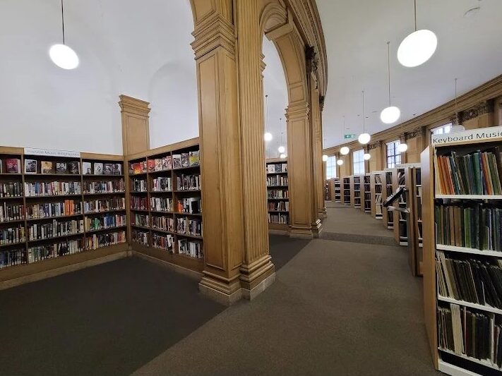 Families visiting Manchester Central Library decorated with Christmas lights and festive displays